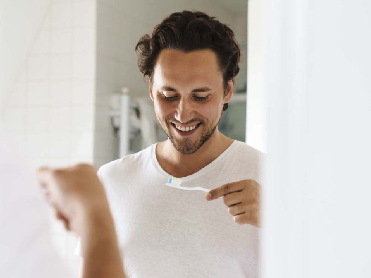 Oxyfresh-pro-formula-toothpaste_copy_man-smiling-looking-at-toothbrush-with-oxyfresh-pro-formula-fresh-mint-toothpaste