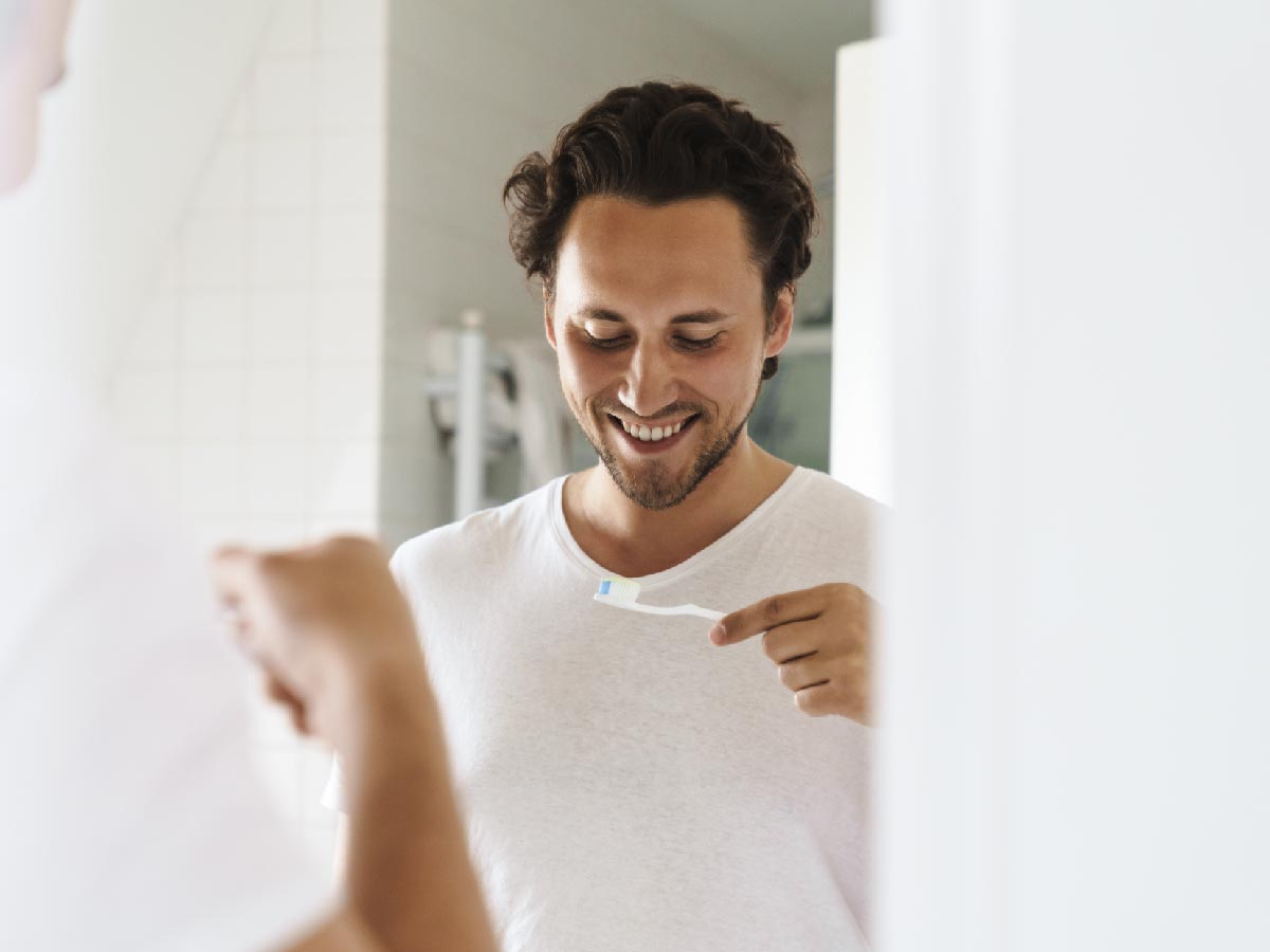 man-smiling-at-toothbrush-with-oxyfresh-fluoride-paste