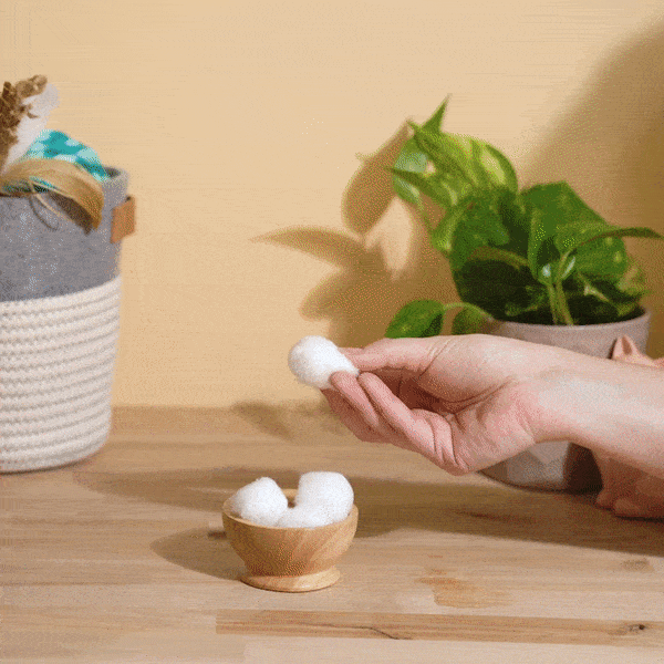 video of woman squirting oxyfresh pet ear cleaner on a cotton ball to be used